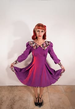 Close up view of a young redhead girl on a retro vintage dress on the urban city.