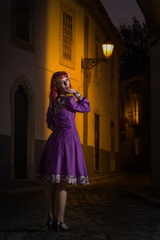 Close up view of a young redhead girl on a retro vintage dress on the urban city.