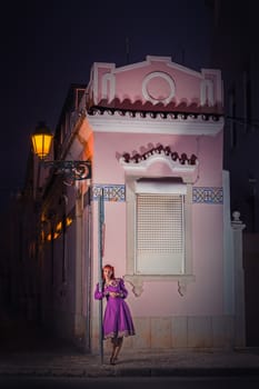 Close up view of a young redhead girl on a retro vintage dress on the urban city.