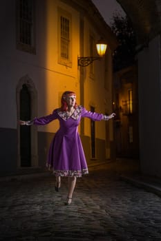 Close up view of a young redhead girl on a retro vintage dress on the urban city.