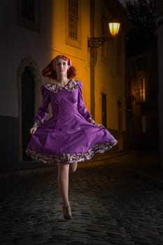 Close up view of a young redhead girl on a retro vintage dress on the urban city.