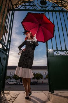 Close up view of a young redhead girl on a retro vintage dress on the urban city.