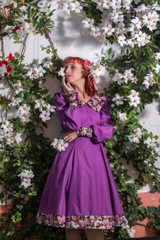 Close up view of a young redhead girl on a retro vintage dress on the urban city.