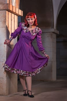 Close up view of a young redhead girl on a retro vintage dress on the urban city.