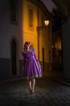 Close up view of a young redhead girl on a retro vintage dress on the urban city.