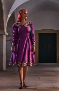 Close up view of a young redhead girl on a retro vintage dress on the urban city.