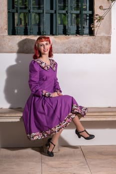 Close up view of a young redhead girl on a retro vintage dress on the urban city.