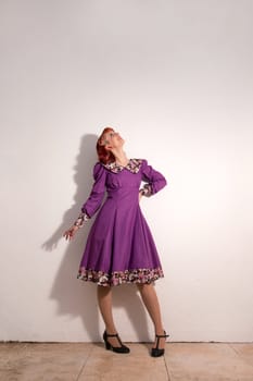 Close up view of a young redhead girl on a retro vintage dress on the urban city.