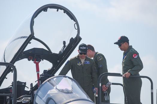 Singapore - February 16, 2016: American Pacific Air Forces soldiers checking out the cockpit of a Singapore Air Force F‑15SG during Singapore Airshow at Changi Exhibition Centre in Singapore.