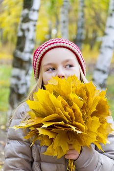 Photo of girl with bouquet from sheets in autumn