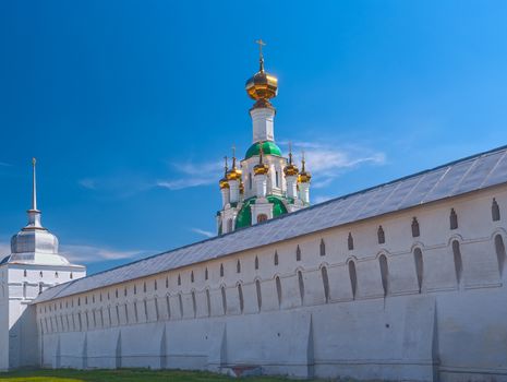 White  Ortodox monastery with gold domesl in sunny spring day