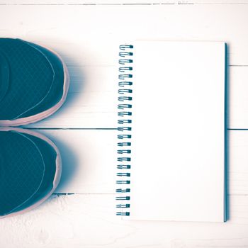 running shoes and notepad on white wood table vintage style