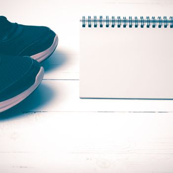 running shoes and notepad on white wood table vintage style