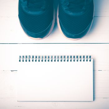 running shoes and notepad on white wood table vintage style