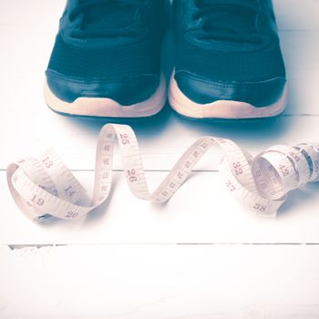 running shoes and measuring tape on white wood table vintage style