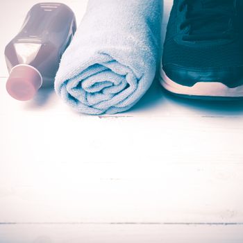 running shoes,towel and orange juice on white wood table vintage style