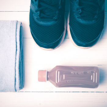 running shoes,towel and orange juice on white wood table vintage style