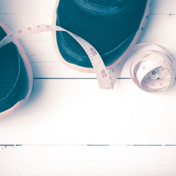 running shoes and measuring tape on white wood table vintage style