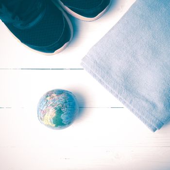 running shoes,towel and earth ball on white wood table concept world healthy vintage style