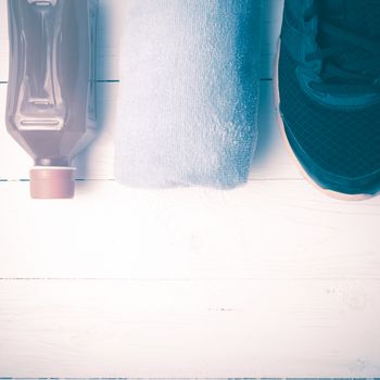 running shoes,towel and orange juice on white wood table vintage style