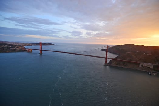 an aerial view of golden gate bridge in san francisco during sunset, taken from a helicopter