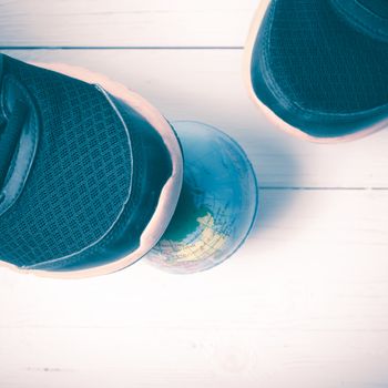 running shoes and earth ball on white wood table concept world healthy vintage style