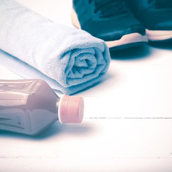 running shoes,towel and orange juice on white wood table vintage style