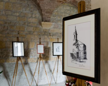 Villanova, Italy - September 7, 2014: Alessio Pegoraro, a contemporary painter from Verona, exhibits his works at the Romanesque abbey of Villanova.