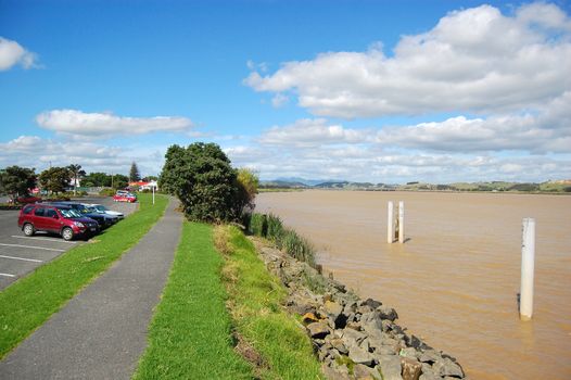 Cars near pedestrian walkway at muddy river coast, Dargaville, Northland, New Zealand