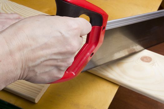 Building, carpentry, repair, teamwork and people concept  close up of builders with arm saw sawing board on table