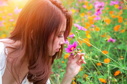 Young beautiful woman smells a flower.