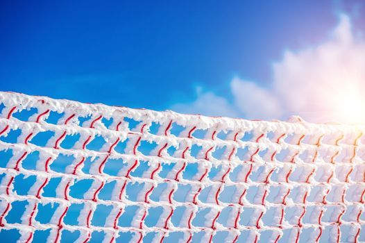 Frozen and snow covered protective net on skiing track. Concept of winter.