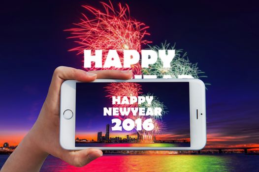 Hand holding smart phone take a photo at happy new year 2016 and Firework dishplay.