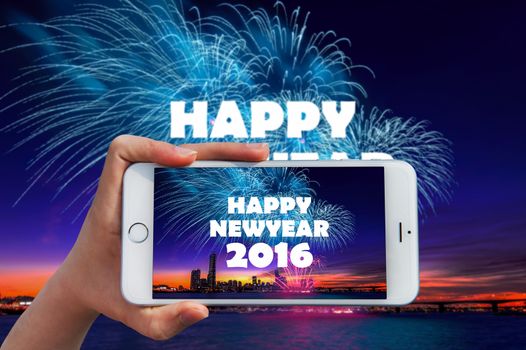 Hand holding smart phone take a photo at happy new year 2016 and Firework dishplay.