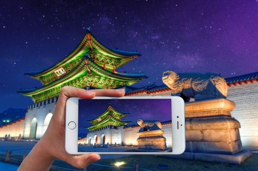 Hand holding smart phone take a photo atGyeongbokgung palace and Milky Way 