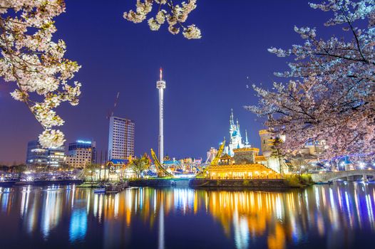 SEOUL, KOREA - APRIL 9, 2015: Lotte World amusement park at night and cherry blossom of Spring, a major tourist attraction in Seoul, South Korea on April 9, 2015