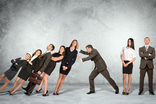 Businessman supporting falling people on wall background, co-working concept