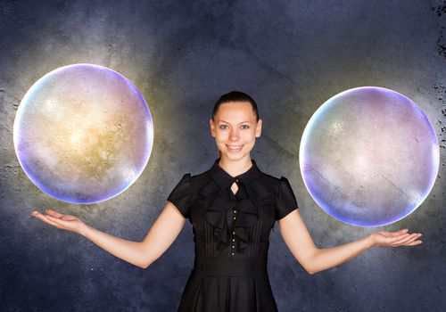 Businesswoman holding two big bubbles and looking at camera, business concept