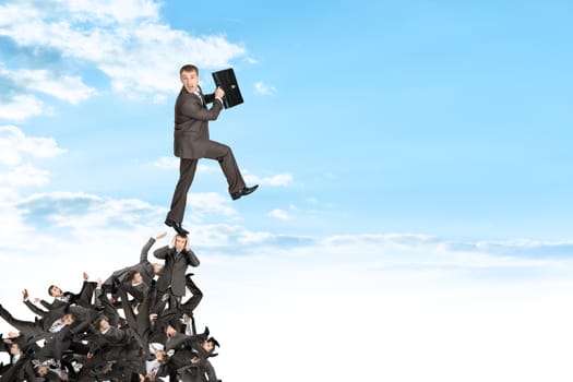 Businessman on pile of people, business concept