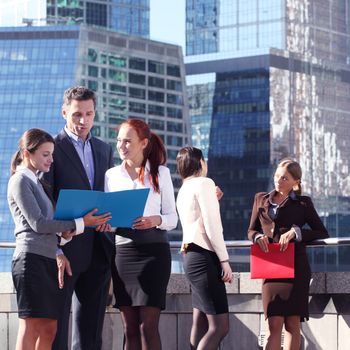 Portrait of business team outside office on skyscrapers background