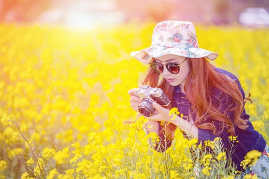 woman taking photos at a rapeseed flowers