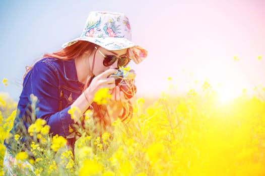 woman taking photos at a rapeseed flowers