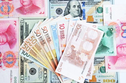 Mixed banknotes, euros, dollars and Chinese yuans. Colorful background, savings, economy and money.