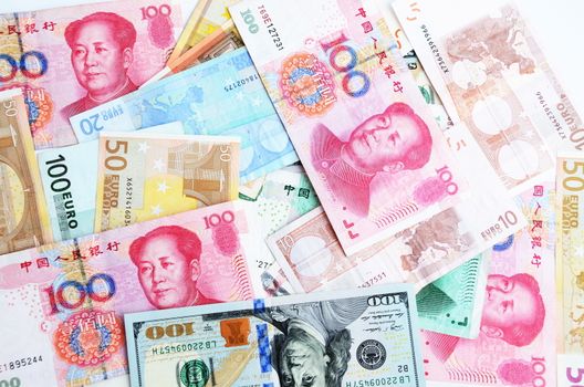 Mixed banknotes, euros, dollars and Chinese yuans. Colorful background, savings, economy and money.