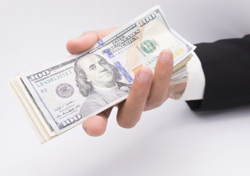 US dollars in business hand isolated on a white background