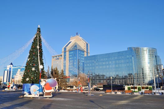 New Year tree against buildings of the Tyumen scientific research institute of regional infectious pathology and 
Gazoil-Plaza, business center. Tyumen, Russia, December, 2015