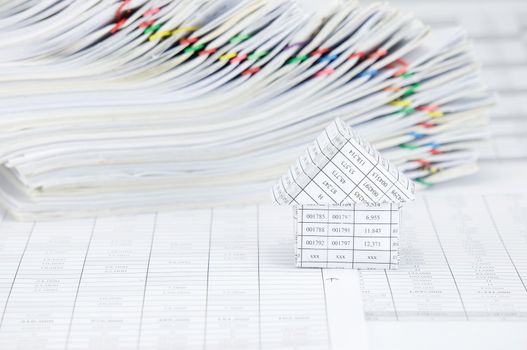 House on finance account have blur overload of paperwork with colorful paperclip as background.