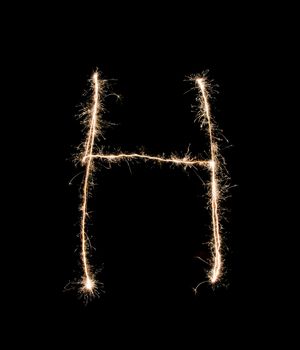 Letter H drew with spakrs on a black background.