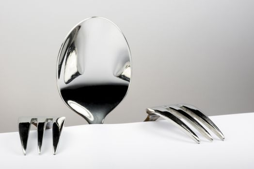 Spoon and two forks formed into conceptual figure
