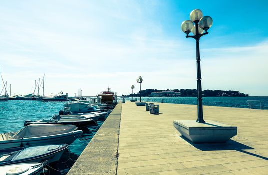 wooden berth with street-lamp on sea background. Pula Croatia